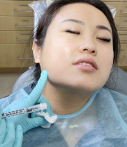 Patient with eyes closed and head back, preparing to receive Botox injection.
